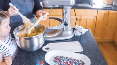 Adım adım. Anne ve kızı mutfakta şekerli kurabiye pişirme.