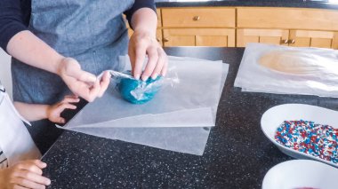 Adım adım. Anne ve kızı mutfakta şekerli kurabiye pişirme.