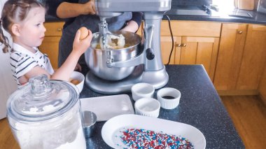 Adım adım. Anne ve kızı mutfakta şekerli kurabiye pişirme.