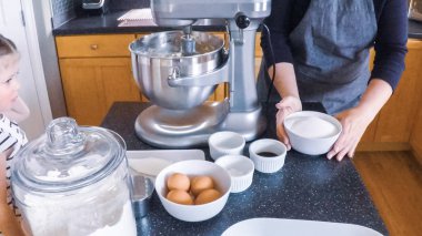 Adım adım. Anne ve kızı mutfakta şekerli kurabiye pişirme.