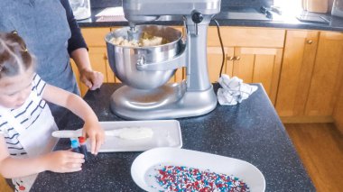 Adım adım. Anne ve kızı mutfakta şekerli kurabiye pişirme.