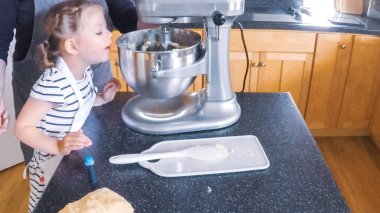 Adım adım. Anne ve kızı mutfakta şekerli kurabiye pişirme.