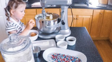 Adım adım. Anne ve kızı mutfakta şekerli kurabiye pişirme.