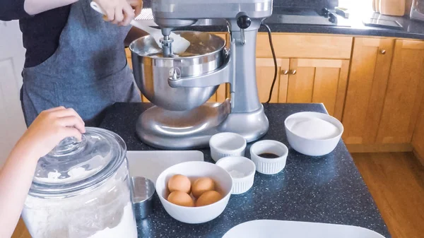 Adım adım. Anne ve kızı mutfakta şekerli kurabiye pişirme.