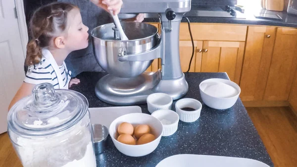 Adım adım. Anne ve kızı mutfakta şekerli kurabiye pişirme.