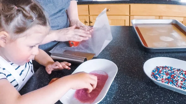 Adım adım. Anne ve kızı mutfakta şekerli kurabiye pişirme.