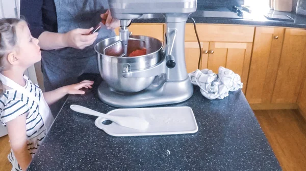 Adım adım. Anne ve kızı mutfakta şekerli kurabiye pişirme.