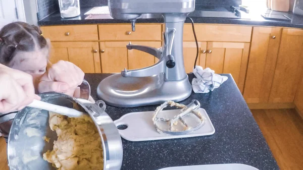 Adım adım. Anne ve kızı mutfakta şekerli kurabiye pişirme.