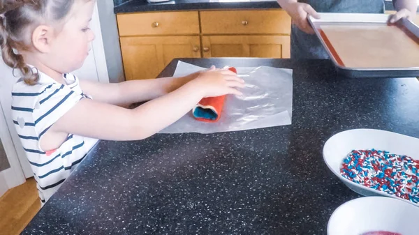 Adım adım. Anne ve kızı mutfakta şekerli kurabiye pişirme.