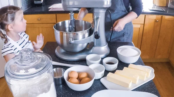 Adım adım. Anne ve kızı mutfakta şekerli kurabiye pişirme.