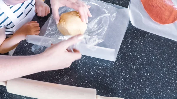 Adım adım. Anne ve kızı mutfakta şekerli kurabiye pişirme.