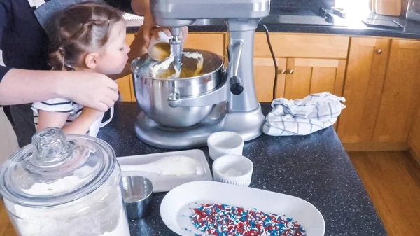 Adım adım. Anne ve kızı mutfakta şekerli kurabiye pişirme.
