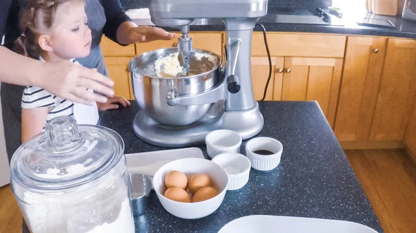 Adım adım. Anne ve kızı mutfakta şekerli kurabiye pişirme.