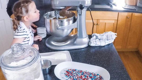 Adım adım. Anne ve kızı mutfakta şekerli kurabiye pişirme.