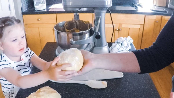 Adım adım. Anne ve kızı mutfakta şekerli kurabiye pişirme.
