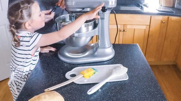 Adım adım. Anne ve kızı mutfakta şekerli kurabiye pişirme.