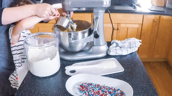 Adım adım. Anne ve kızı mutfakta şekerli kurabiye pişirme.