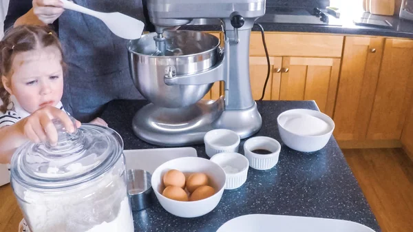 Adım adım. Anne ve kızı mutfakta şekerli kurabiye pişirme.