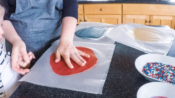 Adım adım. Anne ve kızı mutfakta şekerli kurabiye pişirme.