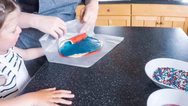 Adım adım. Anne ve kızı mutfakta şekerli kurabiye pişirme.