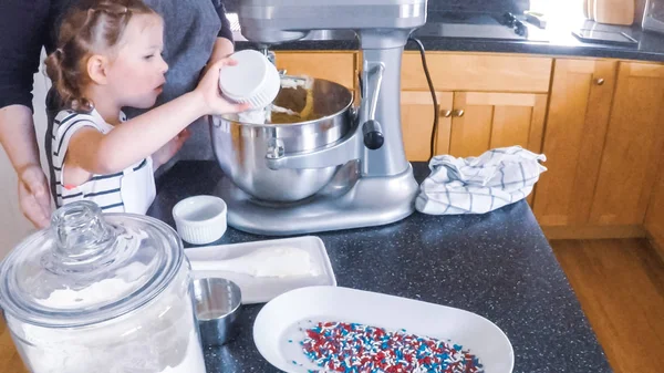 Adım adım. Anne ve kızı mutfakta şekerli kurabiye pişirme.