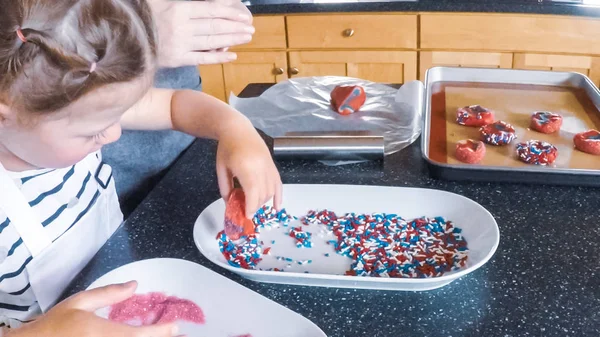 Adım adım. Anne ve kızı mutfakta şekerli kurabiye pişirme.