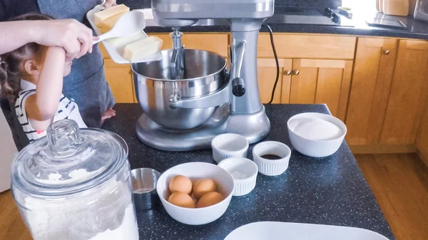 Adım adım. Anne ve kızı mutfakta şekerli kurabiye pişirme.