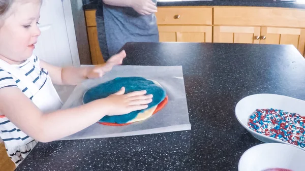 Adım adım. Anne ve kızı mutfakta şekerli kurabiye pişirme.