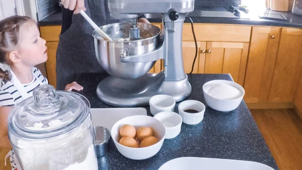 Adım adım. Anne ve kızı mutfakta şekerli kurabiye pişirme.