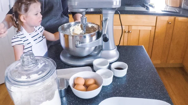 Adım adım. Anne ve kızı mutfakta şekerli kurabiye pişirme.