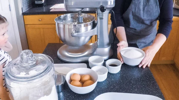 Adım adım. Anne ve kızı mutfakta şekerli kurabiye pişirme.