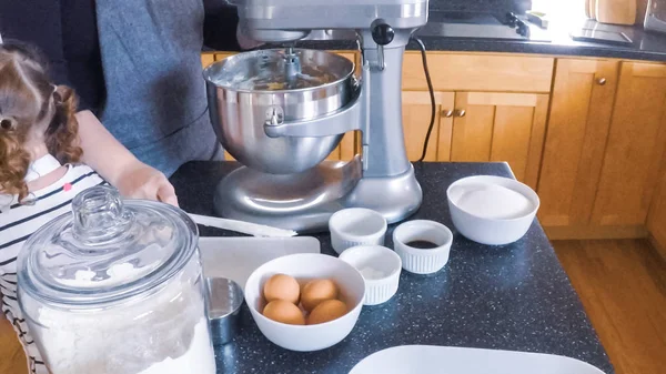 Adım adım. Anne ve kızı mutfakta şekerli kurabiye pişirme.