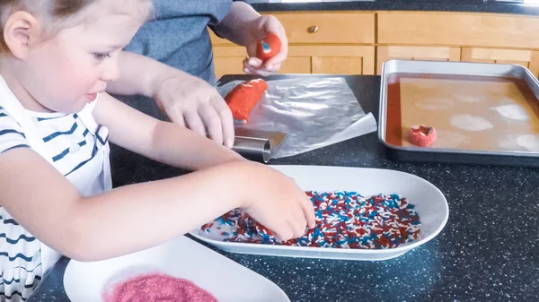 Adım adım. Anne ve kızı mutfakta şekerli kurabiye pişirme.