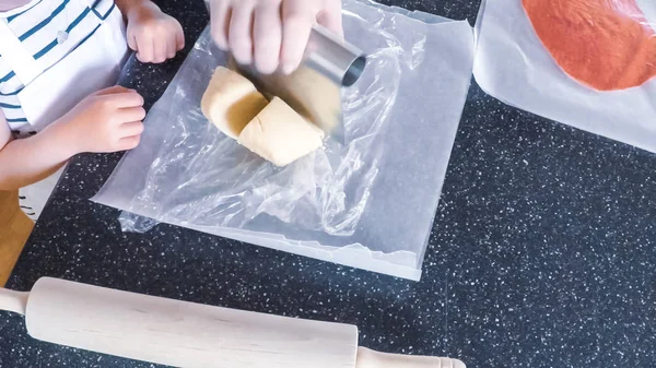 Adım adım. Anne ve kızı mutfakta şekerli kurabiye pişirme.