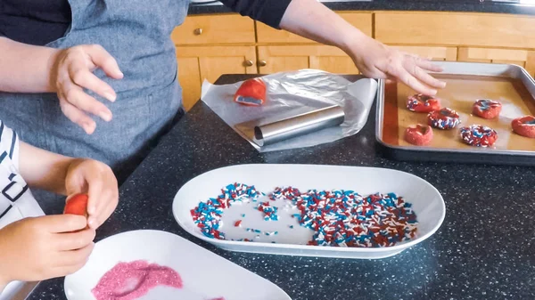 Adım adım. Anne ve kızı mutfakta şekerli kurabiye pişirme.