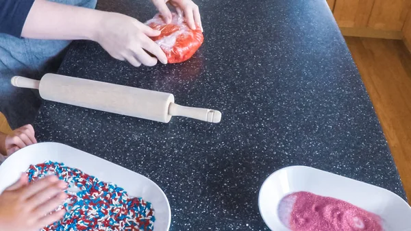 Adım adım. Anne ve kızı mutfakta şekerli kurabiye pişirme.