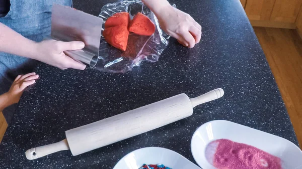 Adım adım. Anne ve kızı mutfakta şekerli kurabiye pişirme.