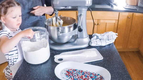 Adım adım. Anne ve kızı mutfakta şekerli kurabiye pişirme.