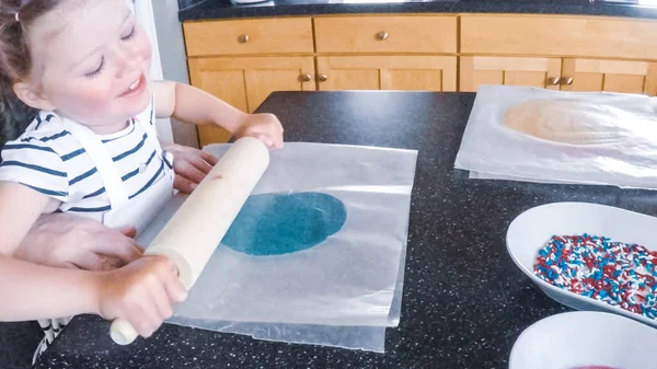 Adım adım. Anne ve kızı mutfakta şekerli kurabiye pişirme.