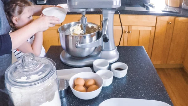 Adım adım. Anne ve kızı mutfakta şekerli kurabiye pişirme.