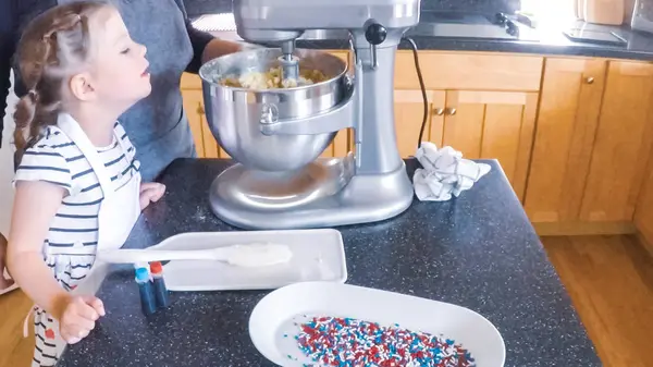 Adım adım. Anne ve kızı mutfakta şekerli kurabiye pişirme.