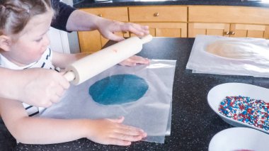 Adım adım. Anne ve kızı mutfakta şekerli kurabiye pişirme.