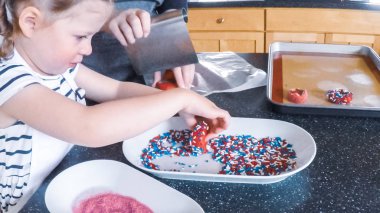 Adım adım. Anne ve kızı mutfakta şekerli kurabiye pişirme.