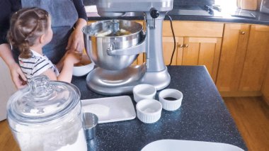 Adım adım. Anne ve kızı mutfakta şekerli kurabiye pişirme.