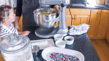 Adım adım. Anne ve kızı mutfakta şekerli kurabiye pişirme.