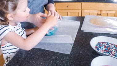 Adım adım. Anne ve kızı mutfakta şekerli kurabiye pişirme.