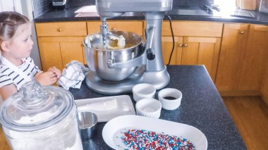 Adım adım. Anne ve kızı mutfakta şekerli kurabiye pişirme.