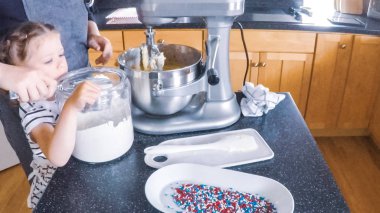 Adım adım. Anne ve kızı mutfakta şekerli kurabiye pişirme.