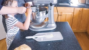 Adım adım. Anne ve kızı mutfakta şekerli kurabiye pişirme.