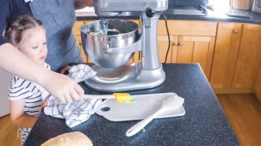 Adım adım. Anne ve kızı mutfakta şekerli kurabiye pişirme.